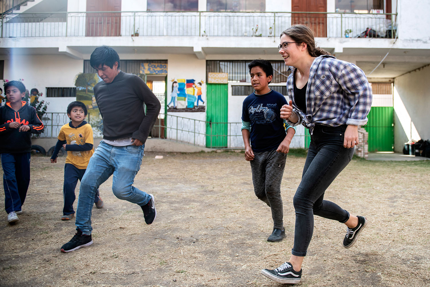 Jugendliche und Kinder rennen in einem Innenhof in Peru, Cajamarca